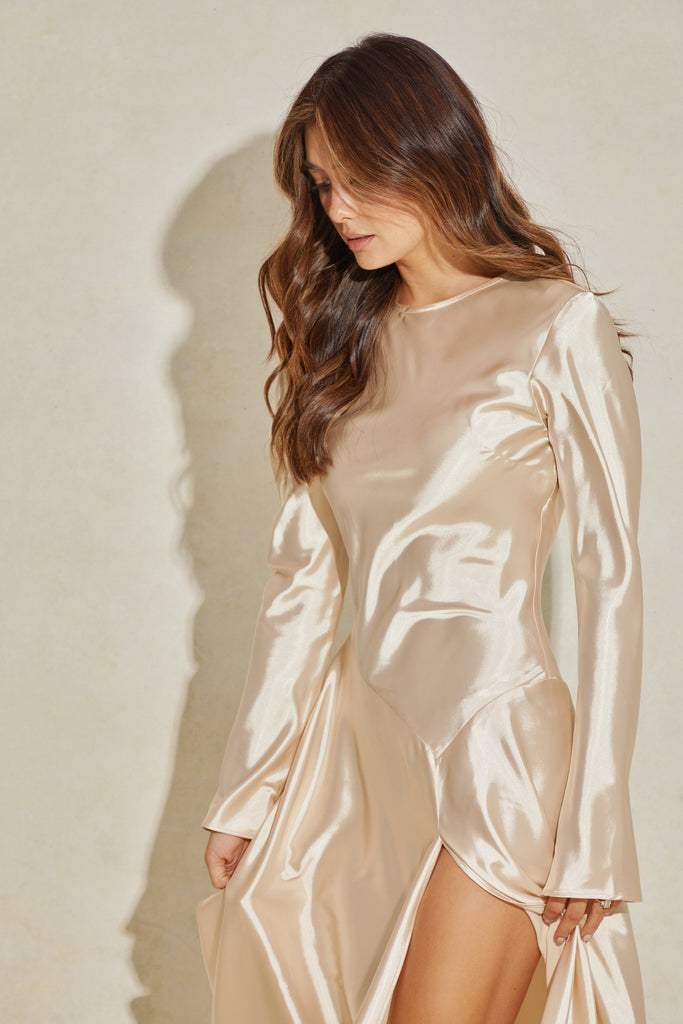 close up of Long sleeve gown in champagne colour with long sleeves and thigh high split 