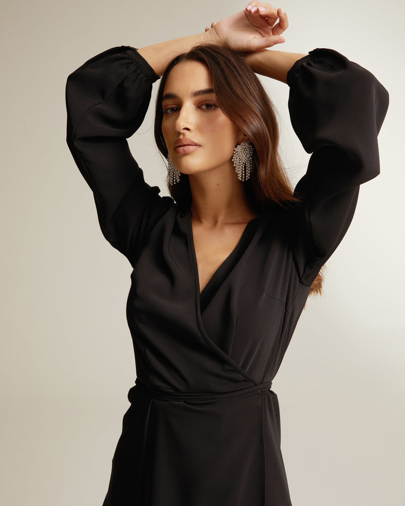 close up of black wrap dress with thigh split and long sleeves