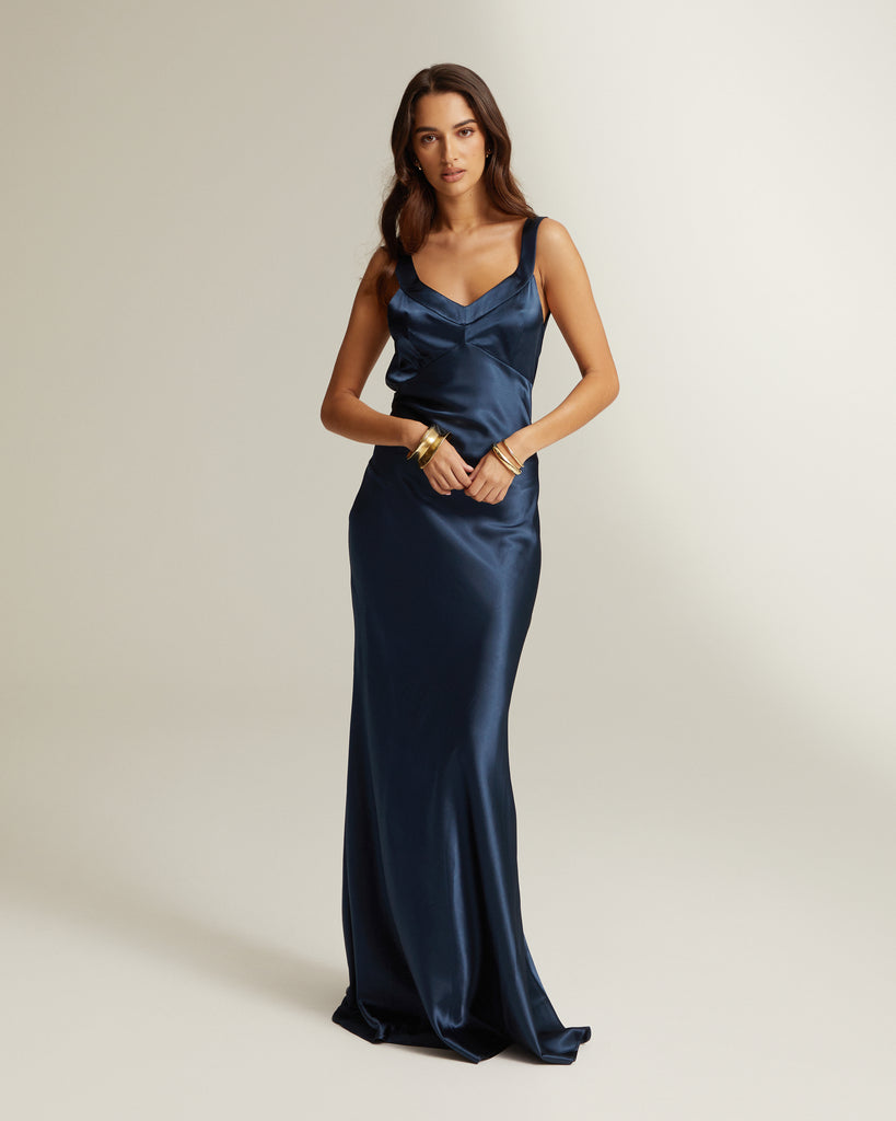 A full-length shot of a navy blue, full length dress with a v-neckline and no sleeves